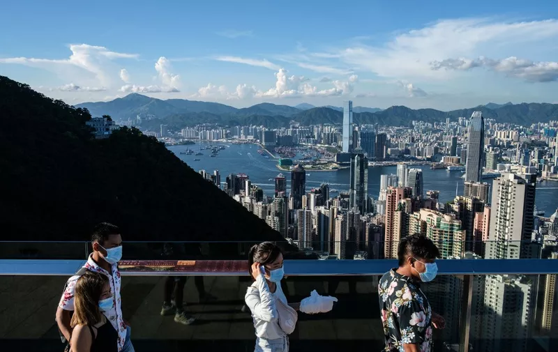 (FILES) In this file photo taken on July 28, 2020, visitors walk along a viewing platform on Victoria Peak in Hong Kong. - Hong Kong and Singapore announced on April 26, 2021 plans to resurrect their scrapped coronavirus travel bubble with dedicated flights between the two cities starting on May 26. (Photo by ANTHONY WALLACE / AFP)