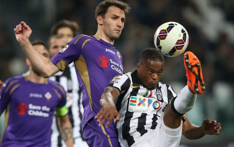 Juventus' French midfielder Patrice Evra (R) fights for the ball with Fiorentina's Croatian midfielder Milan Badelj during the Italian Serie A football match between Juventus and Fiorentina on April 29, 2015 at the "Juventus Stadium" in Turin.  