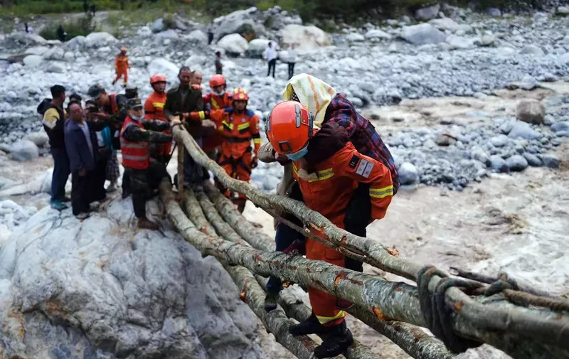 This photo taken on September 5, 2022 shows rescue workers evacuating residents after a 6.6-magnitude earthquake in Luding county, Ganzi, in China's southwestern Sichuan province. (Photo by CNS / AFP) / China OUT