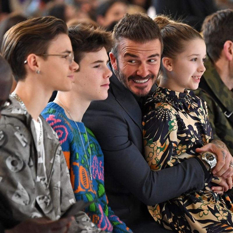 Sons of David and Victoria Beckham, Romeo Beckham (2nd L) and Cruz Beckham (3rd L), David Beckham (C) and his daughter Harper (2nd R) take their seats in the front row for the catwalk show by fashion house Victoria Beckham during their Autumn/Winter 2020 collection on the third day of London Fashion Week in London on February 16, 2020. (Photo by DANIEL LEAL-OLIVAS / AFP)