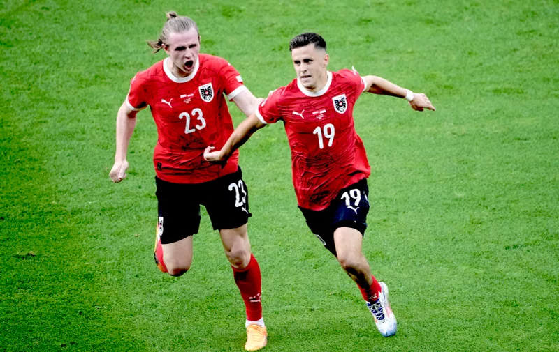 Austria's Christoph Baumgartner, right, celebrates with Patrick Wimmer after scoring his side's second goal during a Group D match between Poland and Austria at the Euro 2024 soccer tournament in Berlin, Germany, Friday, June 21, 2024. (AP Photo/Petr Josek)