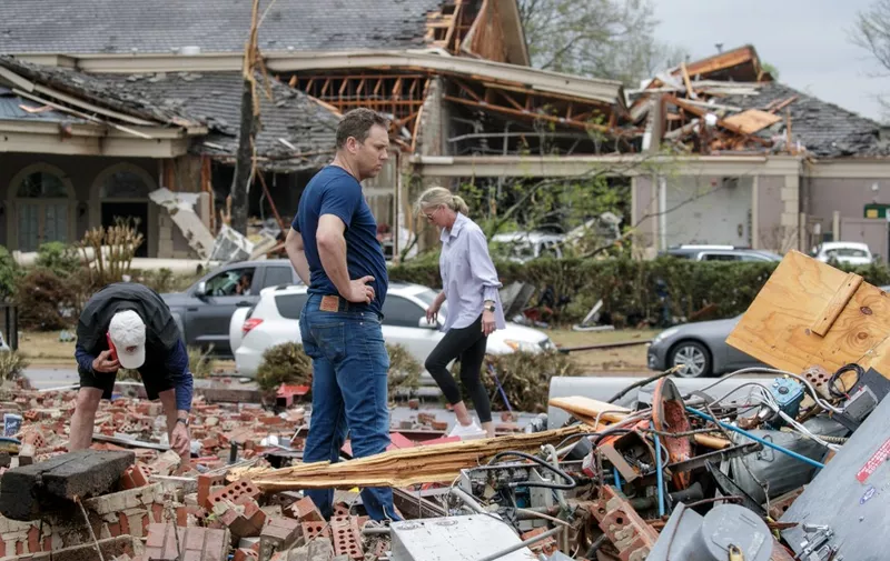 LITTLE ROCK, AR - MARCH 31: Kris French (C) and his family search through rubble for a video recorder they think captured a direct tornado strike to their business, Champs Car Wash, after a tornado damaged hundreds of homes and building on March 31, 2023 in Little Rock, Arkansas. Tornados damaged hundreds of homes and buildings Friday afternoon across a large part of Central Arkansas. Governor Sarah Huckabee Sanders declared a state of emergency after the catastrophic storms that hit on Friday afternoon. According to local reports, the storms killed at least three people.   Benjamin Krain/Getty Images/AFP (Photo by Benjamin Krain / GETTY IMAGES NORTH AMERICA / Getty Images via AFP)