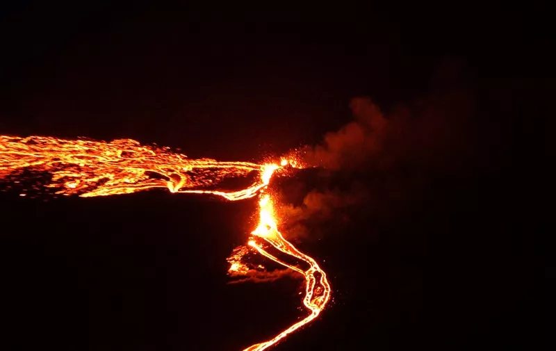 In this still image captured from a hand out video, filmed by the Icelandic Coast Guard, lava flows from the erupting Fagradalsfjall volcano some 50 km west of the Icelandic capital Reykjavik, on March 19, 2021. - A volcano erupted in Iceland on Friday some 40 kilometres (25 miles) from the capital Reykjavik, the Icelandic Meteorological Office said, as a red cloud lit up the night sky and a no-fly zone was established in the area. (Photo by Icelandic Coast Guard / AFP) / RESTRICTED TO EDITORIAL USE - MANDATORY CREDIT "AFP PHOTO / Icelandic Coast Guard" - NO MARKETING NO ADVERTISING CAMPAIGNS - DISTRIBUTED AS A SERVICE TO CLIENTS -