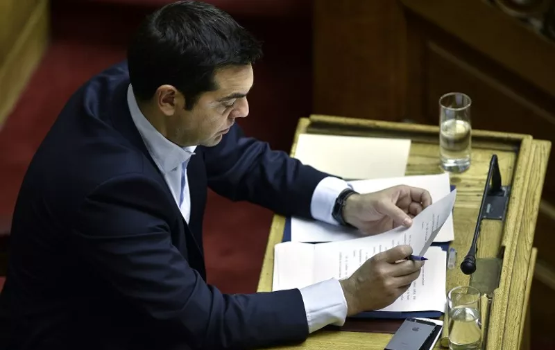 Greek Prime Minister Alexis Tsipras checks his notes before a parliamentary session in Athens on June 28, 2015. Greece will hold a referendum on July 5 on the outcome of negotiations with its international creditors taking place in Brussels today. AFP PHOTO / ANGELOS TZORTZINIS