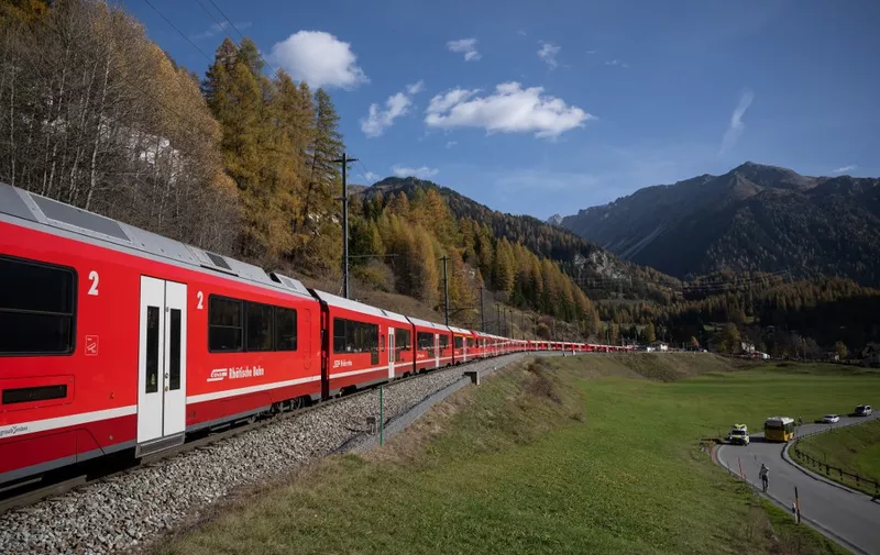A 1910-metre-long train with 100 cars passes near Bergun, on October 29, 2022, during a record attempt by the Rhaetian Railway (RhB) of the World's longest passenger train, to mark the Swiss railway operator's 175th anniversary. - The record attempt is carried out on the Albula Line, from Preda to Thusis, crossing one of the most spectacular railways in the world, recognised as a Unesco World Heritage Site. (Photo by Fabrice COFFRINI / AFP)