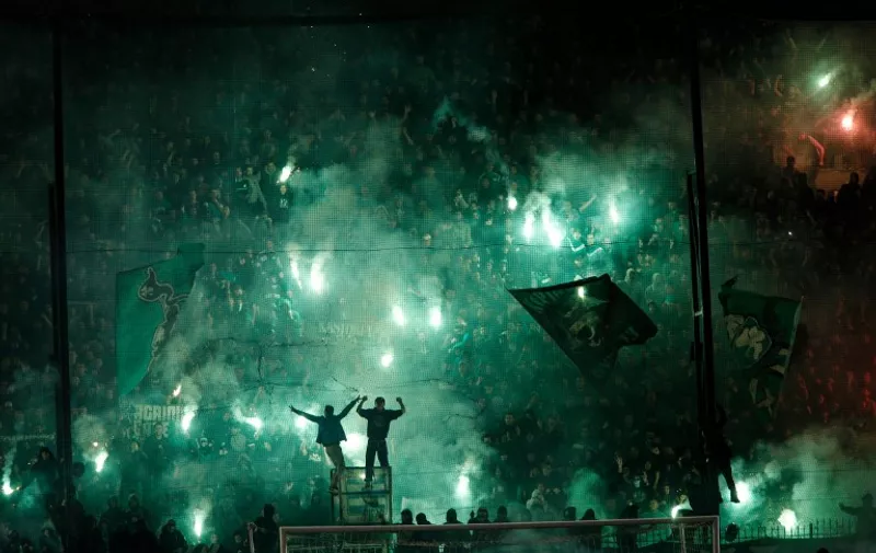 TOPSHOTS
Panathinaikos' fans light flares after the cancellation of the Greek Super League match between Panathinaikos and Olympiakos at Apostolos Nikolaides stadium in Athens on November 21, 2015. Referee Andreas Pappas made the decision 30 minutes after the Super League match was due to start after taking into account the violence both inside and outside the Apostolos Nikolaidis Stadium. Immediately after the decision was announced to the spectators, dozens of fans rushed onto the pitch and fought with riot-trained police. / AFP / SOOC / Alexandros Michailidis