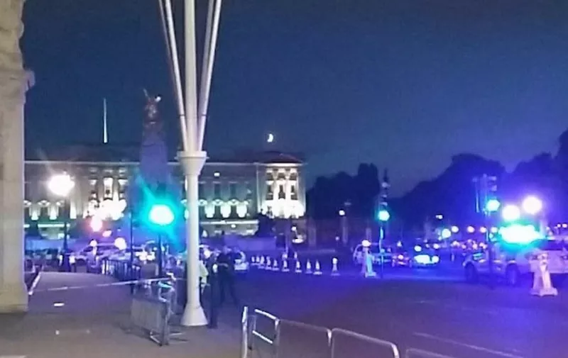 This picture taken from the Twitter account of Matt Vincent, shows policemen stand guarding the streets outside Buckingham Palace in London, on August 25, 2017, after a man was stopped in possession of knife and injured two police officers. - A man was arrested on August 25, after attacking police with a knife outside Queen Elizabeth II's Buckingham Palace residency in London, police said. "The man was stopped...at approximately 20:35 hours (1935 GMT) by officers at the Mall outside Buckingham Palace in possession of knife. Two male police officers suffered minor injuries to their arm," said a Metropolitan Police statement. (Photo by Matt VINCENT / AFP)