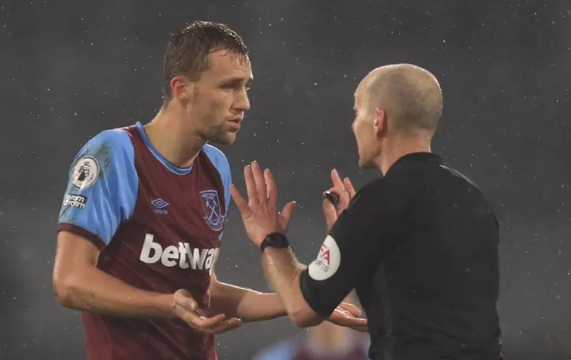 Referee Mike Dean (R) talks to West Ham United's Czech midfielder Tomas Soucek (L) as he sends him off during the English Premier League football match between Fulham and West Ham United at Craven Cottage in London on February 6, 2021. (Photo by Adam Davy / POOL / AFP) / RESTRICTED TO EDITORIAL USE. No use with unauthorized audio, video, data, fixture lists, club/league logos or 'live' services. Online in-match use limited to 120 images. An additional 40 images may be used in extra time. No video emulation. Social media in-match use limited to 120 images. An additional 40 images may be used in extra time. No use in betting publications, games or single club/league/player publications. /