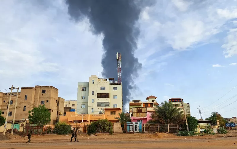 Black smoke billows behind buildings amid ongoing fighting in Khartoum on June 9, 2023. Sudan's warring generals have agreed to a 24-hour ceasefire from June 10, US and Saudi mediators said, acknowledging that previous attempts to pause a conflict now nearing its third month had proved abortive. (Photo by AFP)