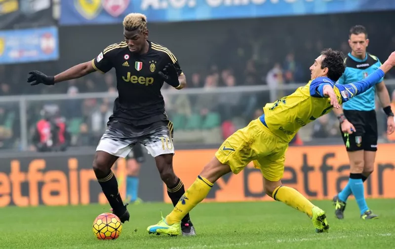 Juventus' midfielder from France Paul Pogba fights for the ball with Chievo's defender from Italy Dario Dainelli (R) during the Serie A football match between Chievo Verona and Juventus on January 31, 2016 at Bentegodi Stadium in Verona.  / AFP / GIUSEPPE CACACE