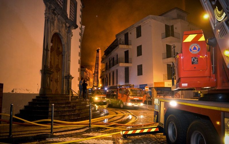 Firefighting vehicles line the street in the historical center of Funchal in Madeira island on August 9, 2016.  
Three people were killed and 1,000 forced to flee their homes overnight as forest fires engulfed the Portuguese island of Madeira, authorities said, as flames menaced the capital Funchal / AFP PHOTO / HELDER SANTOS