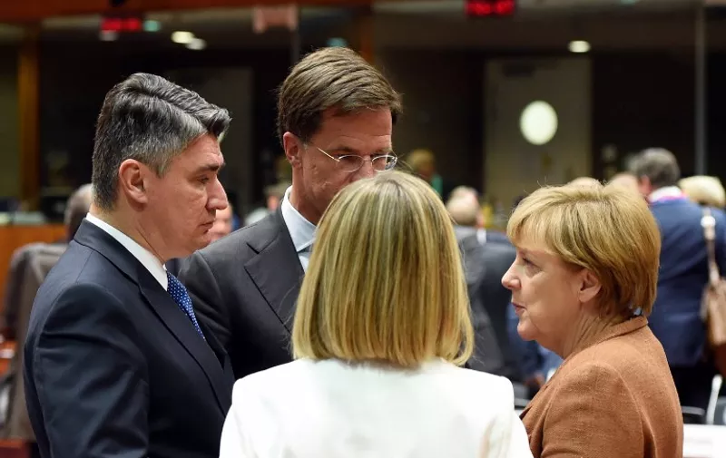 Croatian Prime minister Zoran Milanovic (L) talks with Netherlands' Prime minister Mark Rutte (2ndL) and German federal chancellor Angela Merkel (R) prior to a round table as part of an extraordinary summit on migrants crisis, on September 23, 2015 at the UE headquarters in Brussels. AFP PHOTO/ ALAIN JOCARD