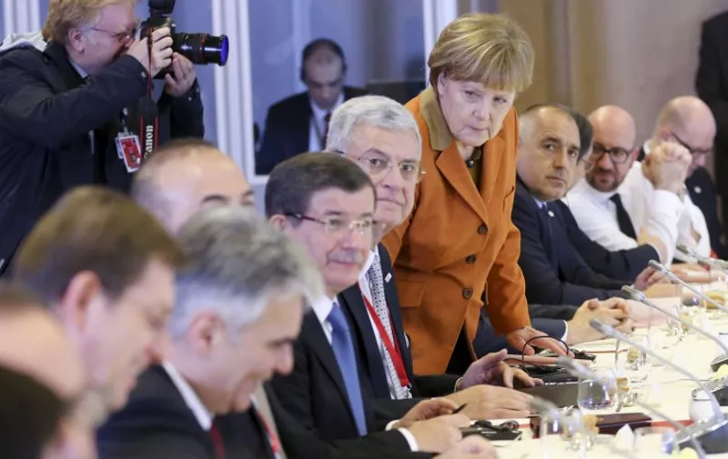 Turkish Prime Minister Ahmet Davutoglu (4th L), German Chancellor Angela Merkel (4th R) and other European leaders attend the lunch of a European Union leaders' summit with Turkey on the migrant crisis at the European Council in Brussels, on March 7, 2016.
EU leaders held a summit with Turkey's prime minister on March 7 in order to back closing the Balkans migrant route and urge Ankara to accept deportations of large numbers of economic migrants from overstretched Greece. The European Union is hardening its stance in a bid to defuse the worst refugee crisis since World War II by increasingly putting the onus on Turkey and EU member Greece in return for aid.
 / AFP / POOL / OLIVIER HOSLET