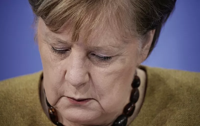 German Chancellor Angela Merkel looks down during a press conference following talks via video conference with Germany's state premiers on the extension of the current partial lockdown, at the Chancellery in Berlin on January 5, 2021. - Germany on January 5 prolonged and toughened up its partial lockdown with tighter limits on social contacts, as Europe's top economy struggles to battle stubbornly high coronavirus infections. Schools, leisure and sporting facilities and most shops will remain shut through to January 31, the German Chancellor said after talks with leaders of Germany's 16 states. (Photo by Michael Kappeler / POOL / AFP)