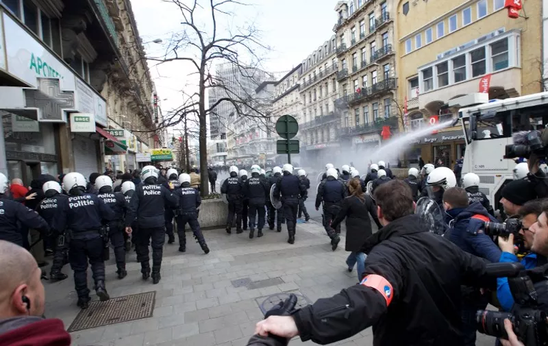 Police use a water cannon to disperse far-right football hooligans outside the stock exchange in Brussels on March 27, 2016 an area which has become an unofficial shrine to victims of the March 22, terror attacks claimed by the Islamic State (IS) group in which 31 people were killed and over 300 injured.
Police used a water cannon to disperse far-right football hooligans outside the stock exchange in Brussels, where people have laid floral tributes to the victims of the March 22, terror attacks on the city. / AFP / Belga / NICOLAS MAETERLINCK / Belgium OUT