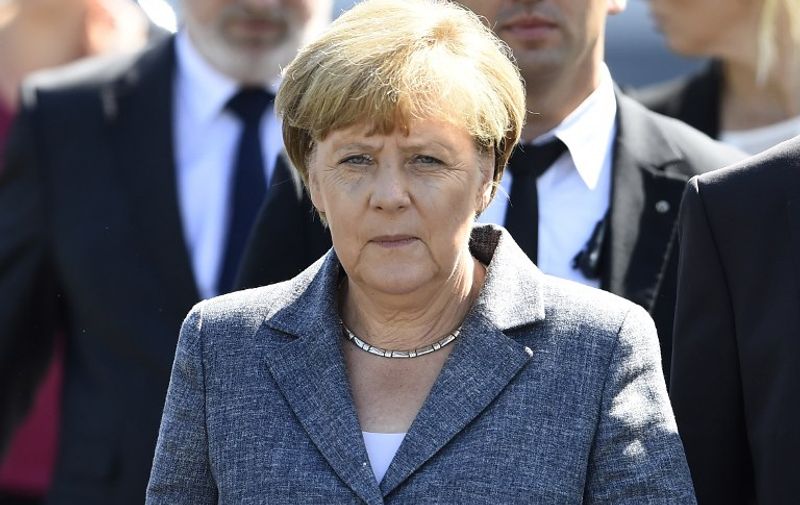 German Chancellor Angela Merkel leaves after a visit to a shelter for asylum-seekers in Heidenau, eastern Germany on August 26, 2015.  Merkel visits the refugee centre hit by violent far-right protests, a day after Berlin said it had eased some asylum rules as thousands more migrants pour into Europe seeking refuge. AFP PHOTO / TOBIAS SCHWARZ