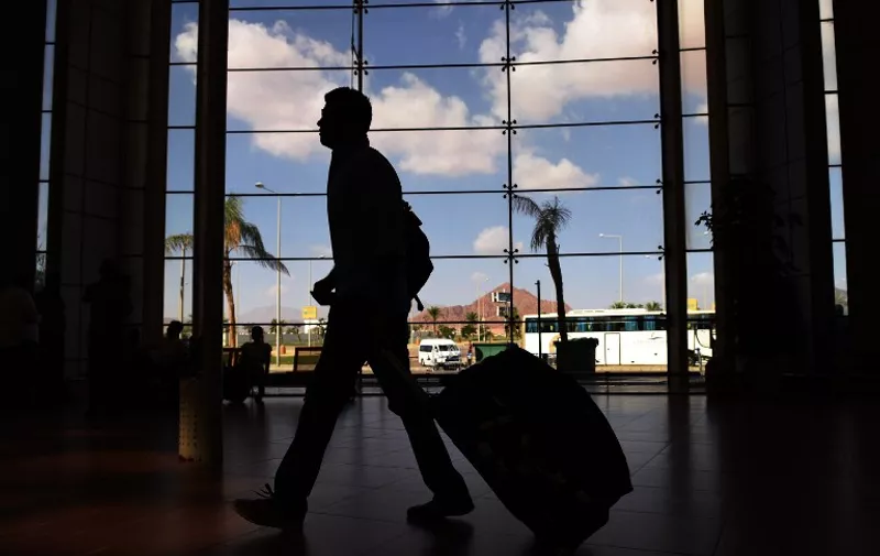 The silhouette of a tourist is seen walking at the airport in Egypt's Red Sea resort of Sharm El-Sheikh on November 6, 2015. Egypt is not allowing British airlines to fly extra repatriation flights to bring back holidaymakers from the Red Sea resort of Sharm el-Sheikh, the airline easyJet said. AFP PHOTO / MOHAMED EL-SHAHED