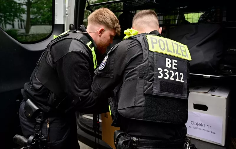 Police officers leave with boxes of materials gathered during the search of a building in Berlin's Kreuzberg distrct in connection with the "Letzte Generation" (Last Generation) group on May 24, 2023. German police on May 24, 2023 carried out raids across seven states targeting climate activists of the "Letzte Generation" (Last Generation) group, which has sparked controversy with street blockades involving protesters glueing themselves to the asphalt. (Photo by John MACDOUGALL / AFP)