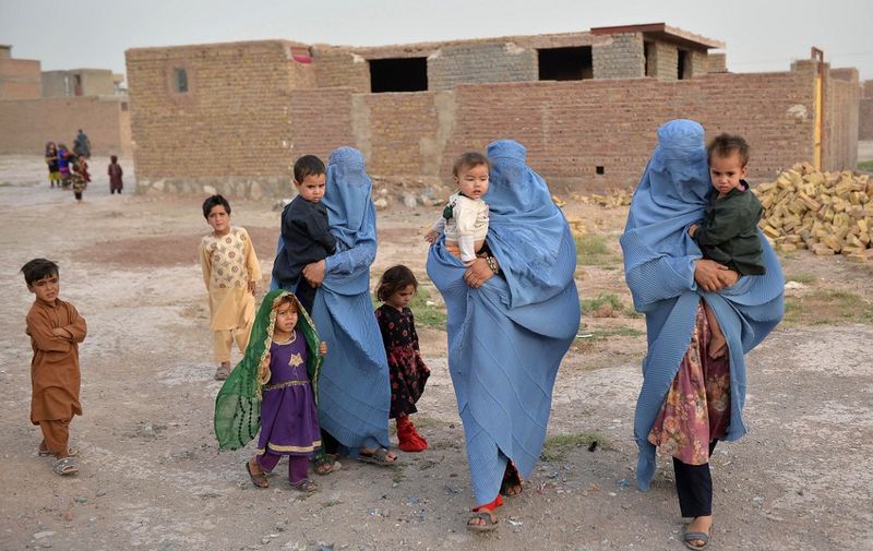 Members of an internally displaced Afghan family who left their home during the ongoing conflict between Taliban and Afghan security forces arrive from Qala-i- Naw, in Enjil district of Herat, on July 8, 2021. (Photo by Hoshang Hashimi / AFP)