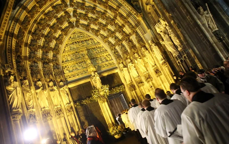 Christians walk through the 'Holy Door' opened by archbishop Cardinal Rainer Maria Woelki at the cathedral of Cologne, Germany, 08 December 2015. The Roman Catholic Archdiocese of Cologne will officially start the 'Holy Year of Mercy' initiated by Pope Francis on 08 December 2015. Photo: ROLAND WEIHRAUCH/dpa (Photo by ROLAND WEIHRAUCH / DPA / dpa Picture-Alliance via AFP)