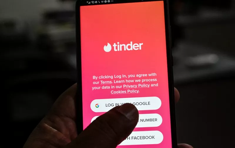 In this photo illustration taken on October 6, 2020, a user checks the dating app Tinder on a mobile phone in Islamabad. Unlike in many countries where meeting online is routine, Pakistanis who use dating apps regularly face harassment and judgmental relatives -- and now also have to contend with a government clampdown. (Photo by Aamir QURESHI / AFP) / To go with 'PAKISTAN-MARRIAGE-DATING', FOCUS by David Stout and Kaneez Fatima in Lahore