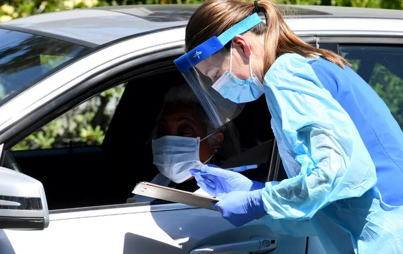 CULVER CITY, CA. - APRIL 24: Workers wearing personal protective equipment (PPE) perform drive-up COVID-19 testing administered from a car at Mend Urgent Care testing site for the novel coronavirus at the Westfield Culver City on April 24, 2020 in the Culver City neighborhood of Los Angeles, California. A nasopharyngeal swab test kit is utilized at this COVID-19 testing center to determine the viral load and virus count of a patient. Los Angeles County 'safer at home' orders remain in effect through May 15 to stop the spread of coronavirus during the worldwide pandemic.   Kevin Winter/Getty Images/AFP