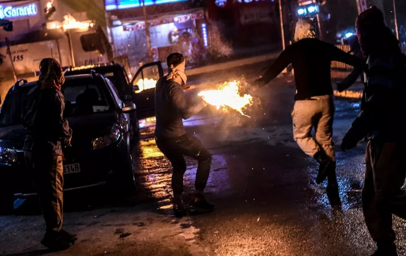 Masked kurdish millitants throw molotov cocktails at a police truck with a water cannon during clashes on August 27,2015 in the Gazi district of Istanbul. Five people, including two children and a soldier, were killed in clashes between Kurdish militants and security forces in Turkey's restive Kurdish-majority southeast on August 27, 2015, local officials and the army said.. AFP PHOTO / OZAN KOSE / AFP / OZAN KOSE