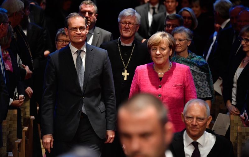 German Chancellor Angela Merkel (R), the President of the Bundesrat (upper house of parliament) and mayor of Berlin Michael Mueller (L) and the Chair of the Council of the Evangelical Church in Germany Heinrich Bedford-Strohm (C, background) arrive to attend an official ceremony on the occasion of the 500th anniversary of the Reformation on October 31, 2017 in Wittenberg. - It is presumed that October 31, 1517 is the date that German theologian Martin Luther published his groundbreaking "95 Theses" of criticism of the Catholic Church, which marks the start of the process that led Protestants to break away from the Roman Catholic Church, a revolution for the Christian religion. The Reformation caused major upheaval in Europe, leading to wars, persecutions and exoduses, including the departure of the Pilgrims for what was later to become America. (Photo by John MACDOUGALL / AFP)