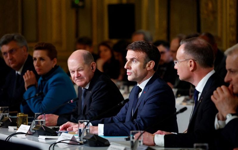 French President Emmanuel Macron, next to Germany's Chancellor Olaf Scholz (L), delivers a speech to open a conference in support of Ukraine with European leaders and government representatives at the Elysee presidential palace in Paris, on February 26, 2024. The meeting at the Elysee Palace will be a chance for participants to "reaffirm their unity as well as their determination to defeat the war of aggression waged by Russia in Ukraine", the French presidency said. (Photo by GONZALO FUENTES / POOL / AFP)