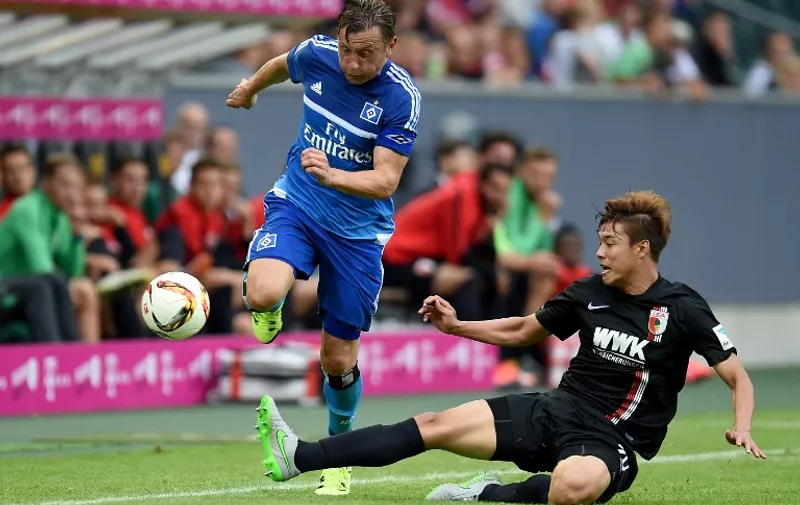 Augsburg's South Korean defender Jeong-Ho Hong and Hamburg's midfielder Ivica Olic (L) vie for the ball during the German Telkom Cup 2015 final football match FC Augsburg and Hamburger SV in Moenchengladbach, western Germany on July 12, 2015. AFP PHOTO / PATRIK STOLLARZ

DFL RULES TO LIMIT THE ONLINE USAGE DURING MATCH TIME TO 15 PICTURES PER MATCH. IMAGE SEQUENCES TO SIMULATE VIDEO IS NOT ALLOWED AT ANY TIME. FOR FURTHER QUERIES PLEASE CONTACT DFL DIRECTLY AT + 49 69 650050. / AFP / PATRIK STOLLARZ