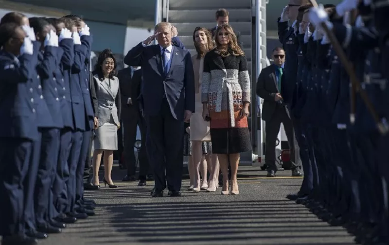 US President Donald Trump (centre L) and First Lady Melania Trump (centre R) walk through an honour cordon as they arrive at Yokota Air Base at Fussa in Tokyo on November 5, 2017.
Trump touched down in Japan on November 5, kicking off the first leg of a high-stakes Asia tour set to be dominated by soaring tensions with nuclear-armed North Korea. / AFP PHOTO / JIM WATSON