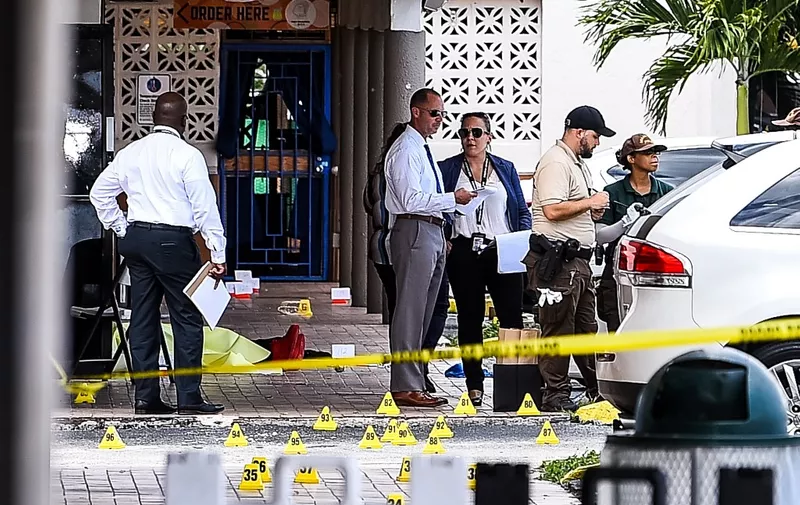 Miami Dade police officers stand in front of Billiard's club that was rented for a concert, after three gunmen killed two people and injured 20 overnight in the Hialeah area of Miami Dade county on May 30 2021. - Two people were killed and at least 20 injured Sunday when three shooters fired indiscriminately into a crowd outside a concert in Miami, Florida, local police said. Gunfire erupted during the early hours outside a billiards hall in a row of businesses near Miami Gardens, northwest of the coastal city's downtown. People crowded the venue, which was "hosting a scheduled event and several patrons were standing outside," Miami-Dade Police Department said in a statement. (Photo by CHANDAN KHANNA / AFP)