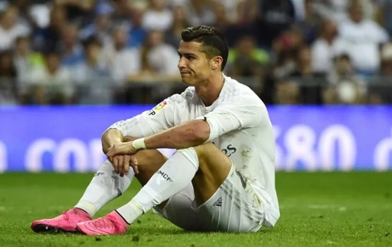 Real Madrid's Portuguese forward Cristiano Ronaldo sits on the ground during the Spanish league football match Real Madrid CF vs Malaga CF at the Santiago Bernabeu stadium in Madrid on September 26, 2015.    AFP PHOTO / PIERRE-PHILIPPE MARCOU