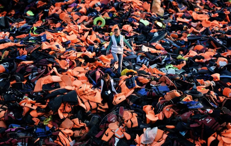 -- AFP PICTURES OF THE YEAR 2015 --
Volunteers walk on a pile of lifejackets left behind by refugees and migrants who arrived to the Greek island of Lesbos after crossing the Aegean sea from Turkey on December 3, 2015.
Under pressure from European partners to better manage a huge influx of migrants, Greece admitted delays in its response but said EU promises had also not been carried out in full. / AFP / ARIS MESSINIS