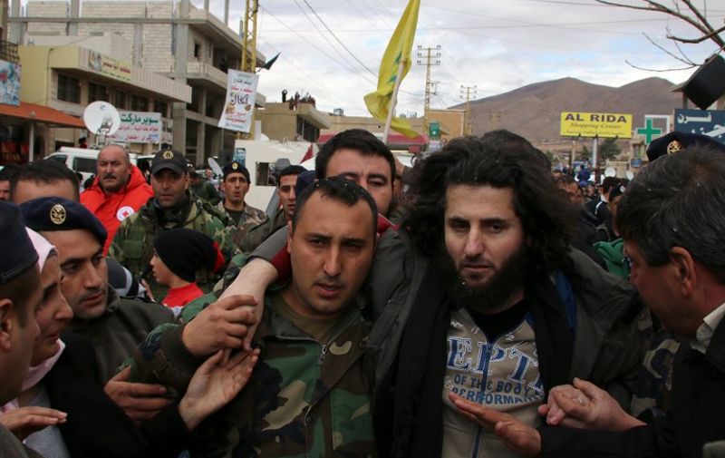A Lebanese soldier helps a fellow member of the security forces, who has been kidnapped by jihadist groups from the eastern border town of Arsal last year, moments after his release on December 1, 2015, in the village of Labweh in the Bekaa Valley. Al-Qaeda's Syrian affiliate freed 16 Lebanese soldiers and police it had held for more than a year in exchange for the release of prisoners and delivery of aid. AFP PHOTO / STR / AFP / -