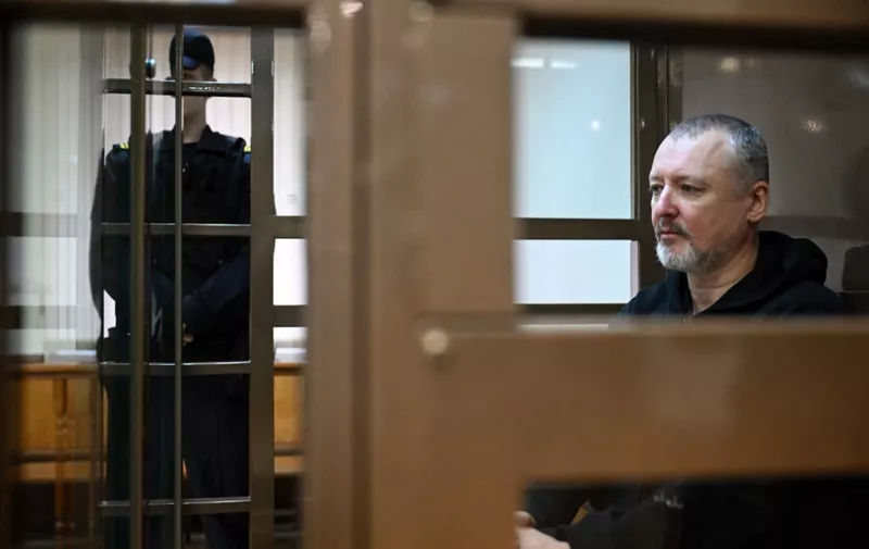 Igor Girkin (Strelkov), the former top military commander of the self-proclaimed "Donetsk People's Republic" and nationalist blogger, who was detained in July and remanded in custody awaiting trial on charges of extremism, sits inside a glass defendants' cage during a hearing to consider an appeal on his extended pre-trial detention at the Moscow City Court in Moscow on October 17, 2023. (Photo by Natalia KOLESNIKOVA / AFP)