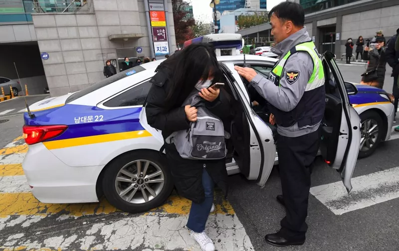 A student gets out of a police car as she arrives to sit the annual College Scholastic Ability Test, a standardised exam for college entrance, at a high school in Seoul on November 23, 2017. An annual hush descended upon South Korea on November 23 as hundreds of thousands of students sat the crucial collegue entrance exam, delayed for a week by a rare quake. (Photo by JUNG Yeon-Je / AFP)