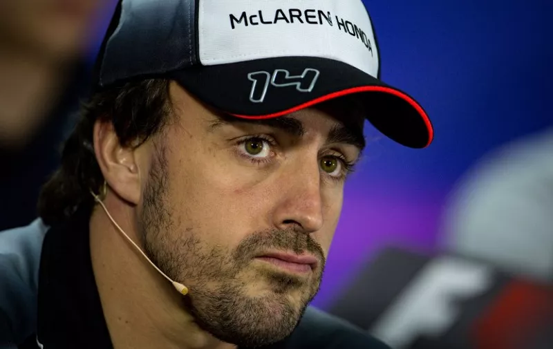 McLaren Honda's Spanish driver Fernando Alonso gestures during the drivers press conference ahead of the Formula One Bahrain Grand Prix at the Sakhir circuit in the desert south of the Bahraini capital, Manama, on March 31, 2016.
Alonso will not take part in this weekend's Grand Prix in Bahrain for medical reasons following his dramatic, death-defying crash at the Australian GP. / AFP / ANDREJ ISAKOVIC