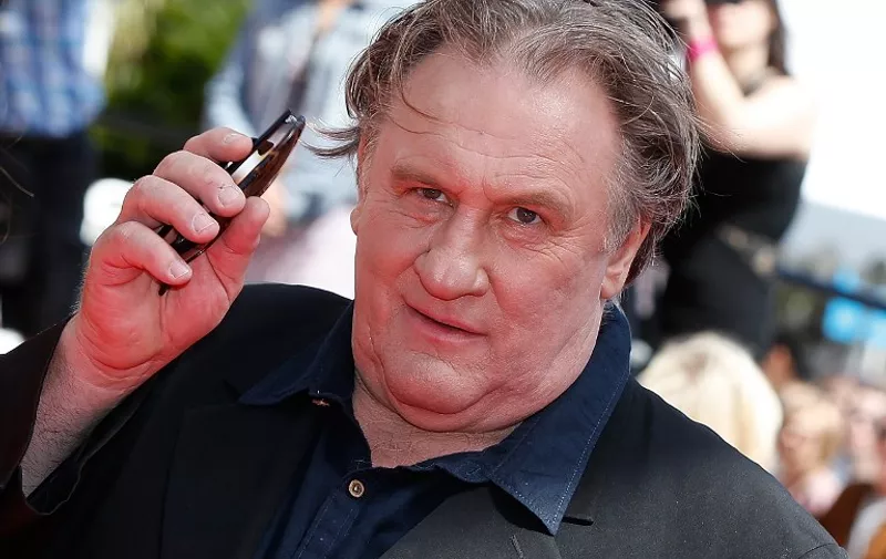 French actor Gerard Depardieu waves as he arrives for the screening of the film "Valley of Love" at the 68th Cannes Film Festival in Cannes, southeastern France, on May 22, 2015. AFP PHOTO / VALERY HACHE
