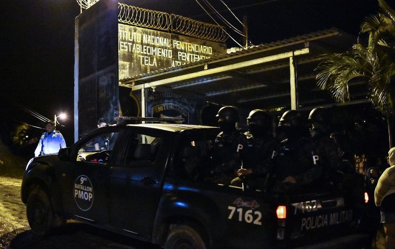 Members of the Honduras's Police Military arrive to the penitentiary of Tela, Atlantida department, Honduras, on December 21, 2019, after a fight between rival gangs ocurred in the prison. - At least 18 inmates died Friday night in a confrontation at the prison of the port of Tela, Honduran Caribbean, authorities said. (Photo by STR / AFP)