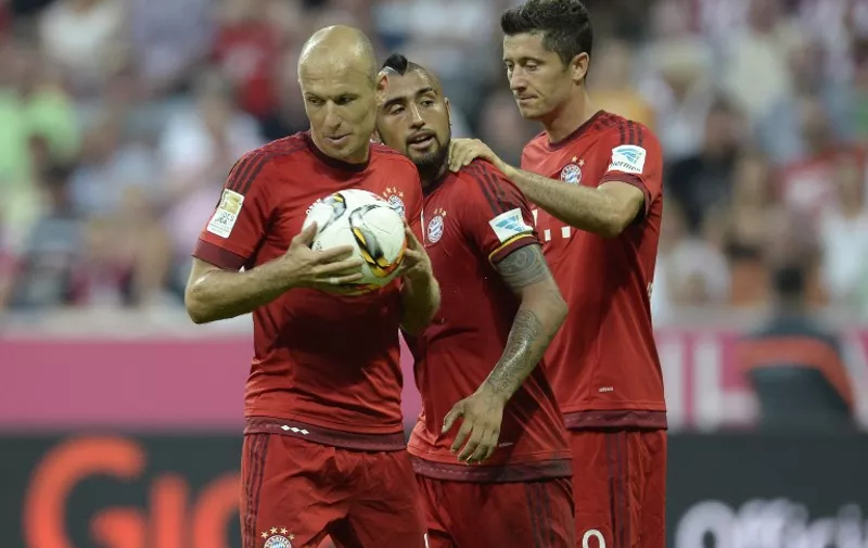 (L-R) Bayern Munich's Dutch midfielder Arjen Robben takes the ball for the penalty kick beside of Bayern Munich's Chilian midfielder Arturo Vidal and Bayern Munich's Polish striker Robert Lewandowski during the German first division Bundesliga football match Bayern Munich vs Bayer 04 Leverkusen in Munich, southern Germany, on August 29, 2015.
RESTRICTIONS: DURING MATCH TIME: DFL RULES TO LIMIT THE ONLINE USAGE TO 15 PICTURES PER MATCH AND FORBID IMAGE SEQUENCES TO SIMULATE VIDEO. 
== RESTRICTED TO EDITORIAL USE ==
FOR FURTHER QUERIES PLEASE CONTACT DFL DIRECTLY AT + 49 69 650050.