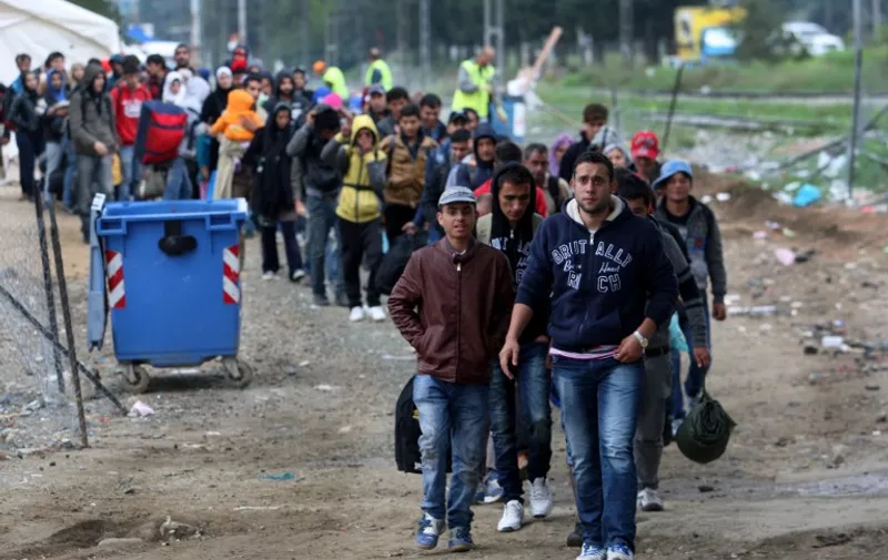 Migrants and refugees walk to cross Greek-Macedonian border near the village of Idomeni, in northern Greece on October 14, 2015. More than 400,000 refugees, mostly Syrians and Afghans, arrived in Greece since early January while dozens were drowned trying to make the crossing. In total 710,000 have entered the EU through Greece and Italy during the same period, according to the European Agency Frontex border surveillance. The migration issue has caused deep divisions within the European Union, which is trying to set the distribution of migrants among its member countries or limit the flow.  AFP PHOTO /STRINGER