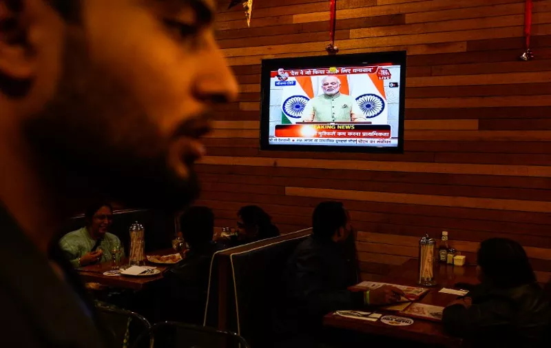 Indian Prime Minister Narendra Modi is seen on the television inside a restaurant as he address the nation in New Delhi on December 31, 2016.
India's Prime Minister Narendra Modi December 31 announced a series of cash handouts, loans and sops for farmers, women and marginalised social sections of society while defending his shock cash-ban decision of November 8. / AFP PHOTO / CHANDAN KHANNA