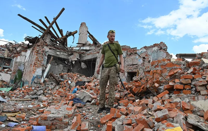 A Ukrainian serviceman inspects the ruins of Lyceum building, suspected to have been destroyed after a missile strike near Kharkiv on July 5, 2022, amid the Russian invasion of Ukraine. (Photo by SERGEY BOBOK / AFP)