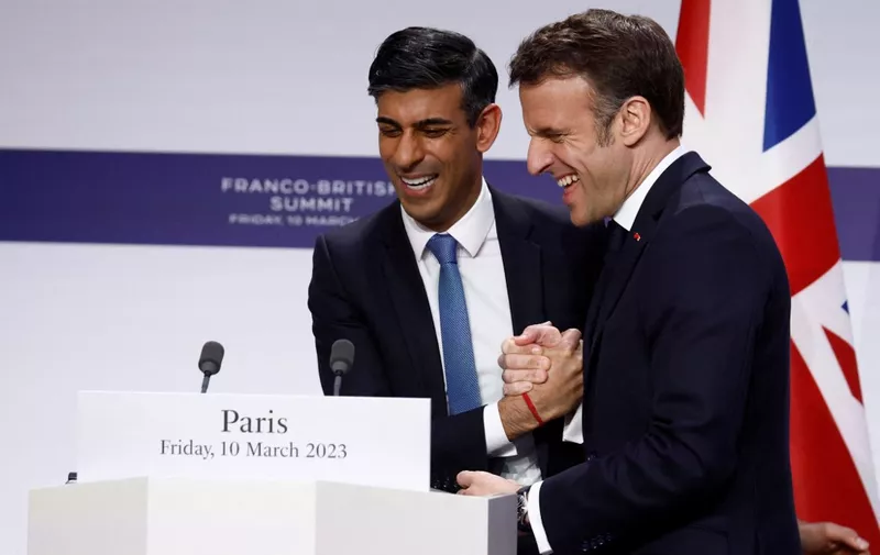 French President Emmanuel Macron shakes hands with British Prime Minister Rishi Sunak at the end of a press conference with British Prime Minister as part of the Franco-British Summit held at the Elysee Palace in Paris, on March 10, 2023. (Photo by GONZALO FUENTES / POOL / AFP)