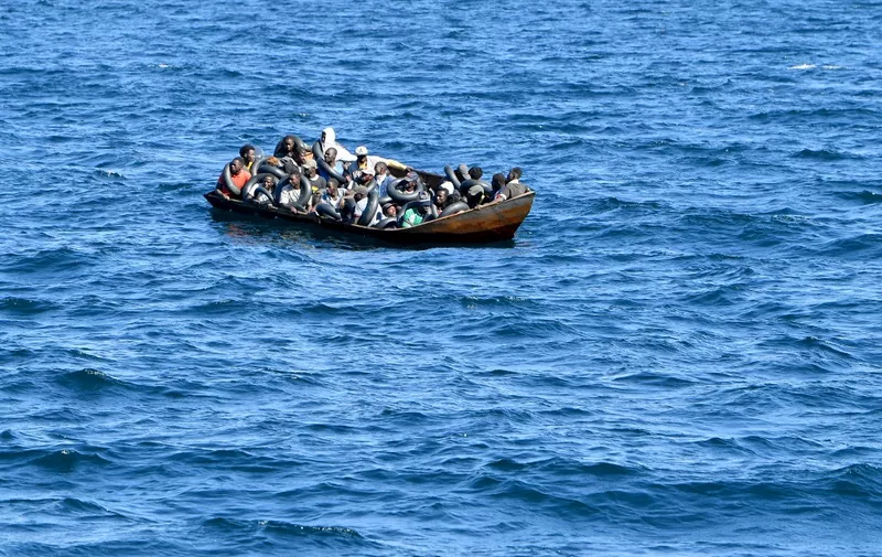 Migrants of African origin trying to flee to Europe are crammed on board of a small boat, as Tunisian coast guards prepare to transfer them onto their vessel, at sea between Tunisia and Italy, on August 10, 2023. Mediterranean Sea crossing attempts from Tunisia have multiplied following a incendiary speech by the Tunisian president who had alleged that "hordes" of irregular migrants were causing crime and posing a demographic threat to the mainly Arab country. (Photo by FETHI BELAID / AFP)