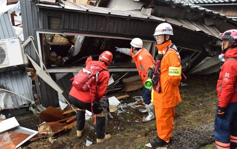 Firefighters search a collapsed house for survivors in the city of Suzu, Ishikawa prefecture on January 3, 2024, after a major 7.5 magnitude earthquake struck the Noto region in Ishikawa prefecture on New Year's Day. Japanese rescuers scrambled to search for survivors on January 3 as authorities warned of landslides and heavy rain after a powerful earthquake that killed at least 62 people. (Photo by JIJI Press / AFP) / Japan OUT