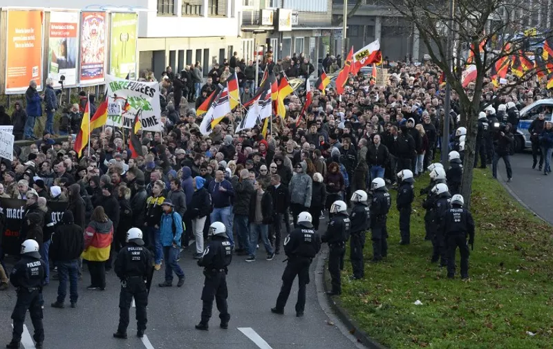 German far-right supporters demonstrate at Cologne`s train station on January 9, 2016. 
Chanting "Merkel out" and waving German flags, supporters of the xenophobic PEGIDA movement vented their anger Saturday against migrants after a rash of sexual assaults in the western city of Cologne. / AFP / Roberto Pfeil