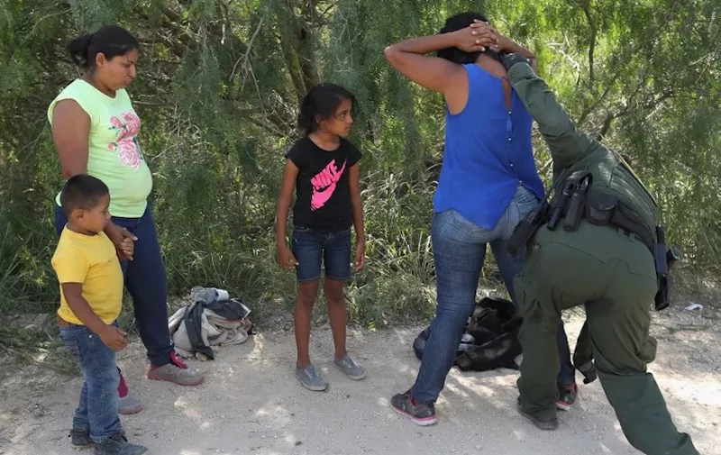 MCALLEN, TX - JUNE 12: Central American asylum seekers are taken into custody by U.S. Border Patrol agents on June 12, 2018 near McAllen, Texas. The families were then sent to a U.S. Customs and Border Protection (CBP) processing center for possible separation. U.S. border authorities are executing the Trump administration's "zero tolerance" policy towards undocumented immigrants. U.S. Attorney General Jeff Sessions also said that domestic and gang violence in immigrants' country of origin would no longer qualify them for political asylum status.   John Moore/Getty Images/AFP