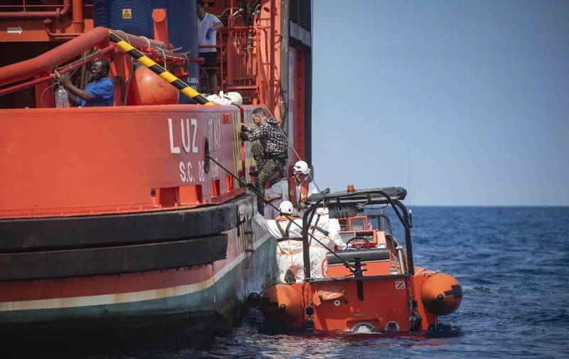 Salvamento Maritimo sea search and rescue agency personnel help a man board their vessel after migrants were rescued from a boat stranded in the Strait of Gibraltar during a rescue operation with the Spanish Guardia Civil that saw 157 migrants rescued on September 8, 2018. - While the overall number of migrants reaching Europe by sea is down from a peak in 2015, Spain has seen a steady increase in arrivals this year and has overtaken Italy as the preferred destination for people desperate to reach the continent. Over 33,000 migrants have arrived in Spain by sea and land so far this year, and 329 have died in the attempt, according to the International Organization for Migration. (Photo by Marcos Moreno / AFP)
